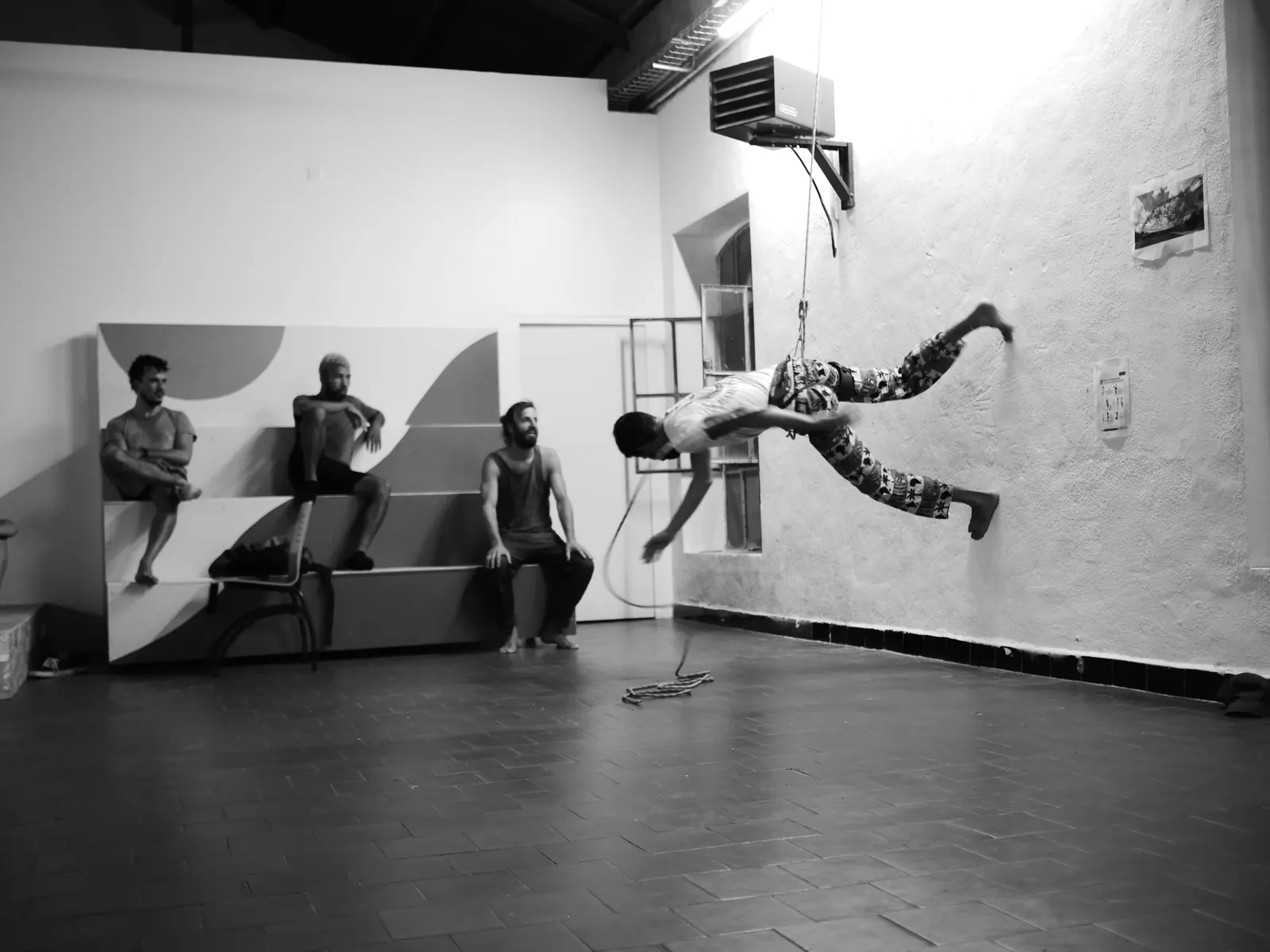 A dancer runs along a studio wall on a rope while three dancers watch, Coco Velten, Marseille