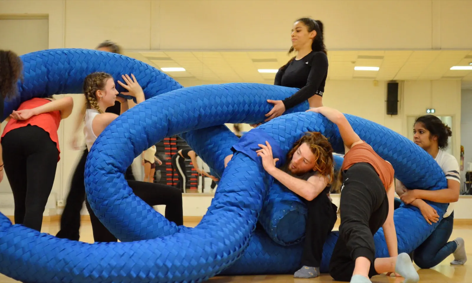Students dancing inside the coils of a giant blue rope